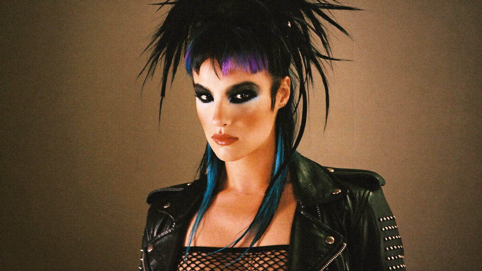 1980s punk woman with dramatic smoky black eyes, electric blue neon eyeshadow, spiky hair and studded leather jacket