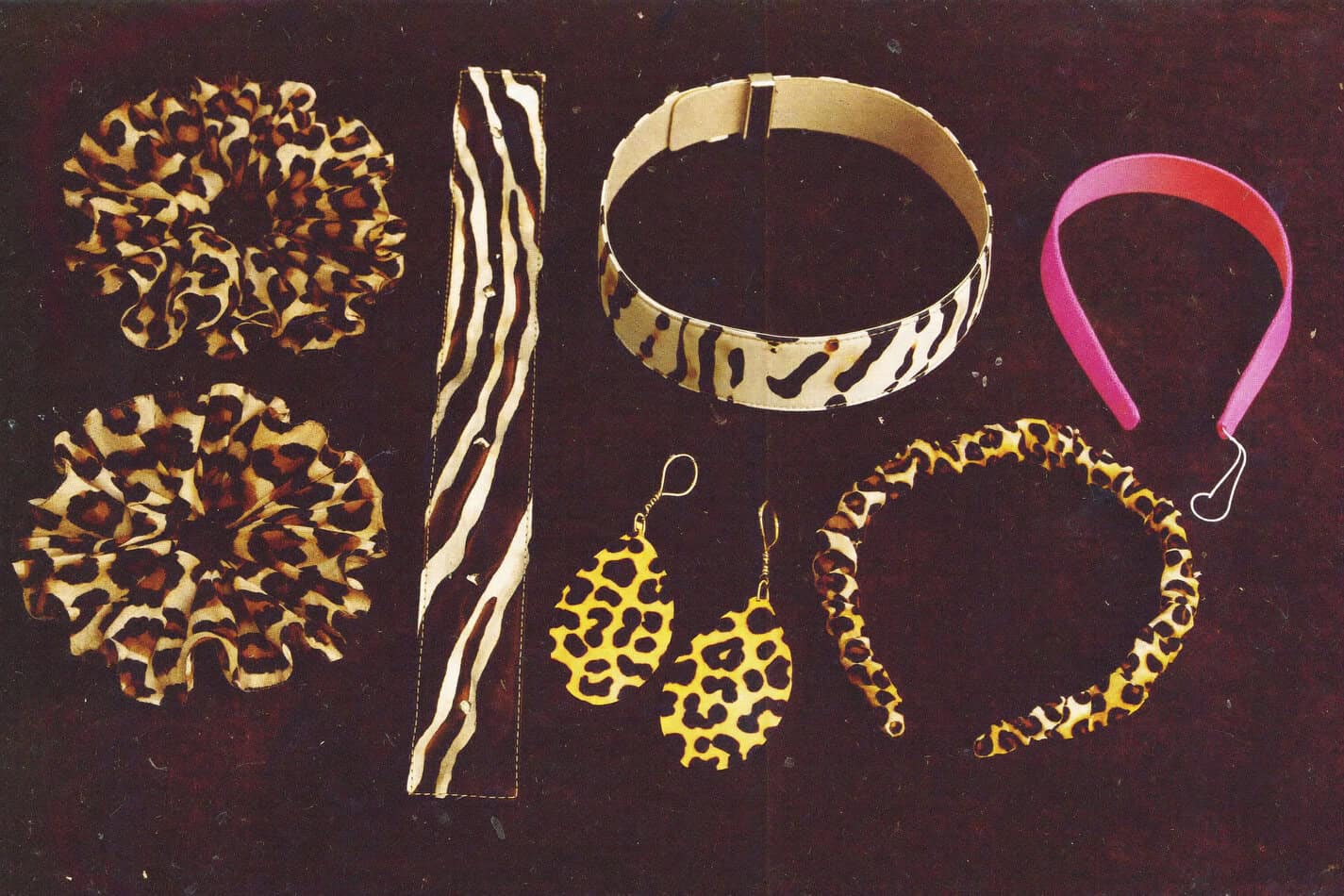 Vintage 1980s animal print accessories including leopard scrunchies, zebra belt, and cheetah earrings