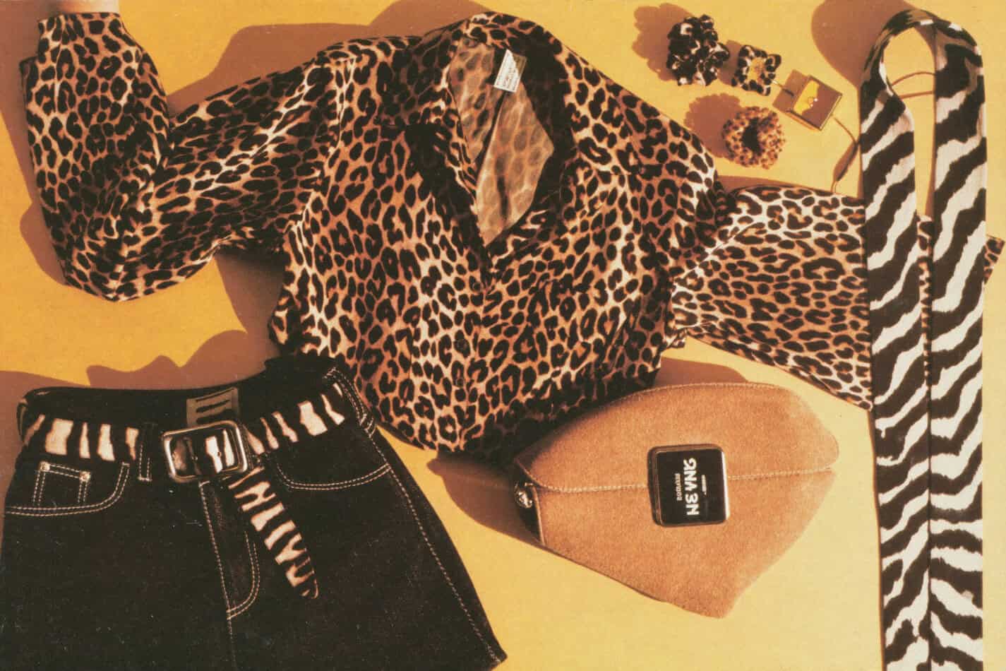 80s animal print fashion flat-lay with leopard print blouse, zebra belt, cheetah scrunchies