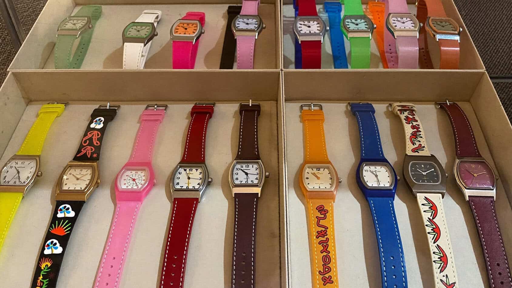 Vintage 1980s Swatch watch collection displayed in shadow box with colorful models