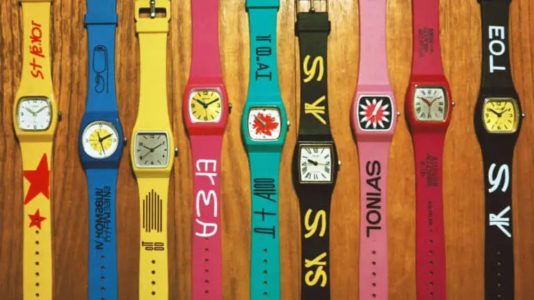 1980s Swatch watch collection flat-lay on wood surface with neon colors
