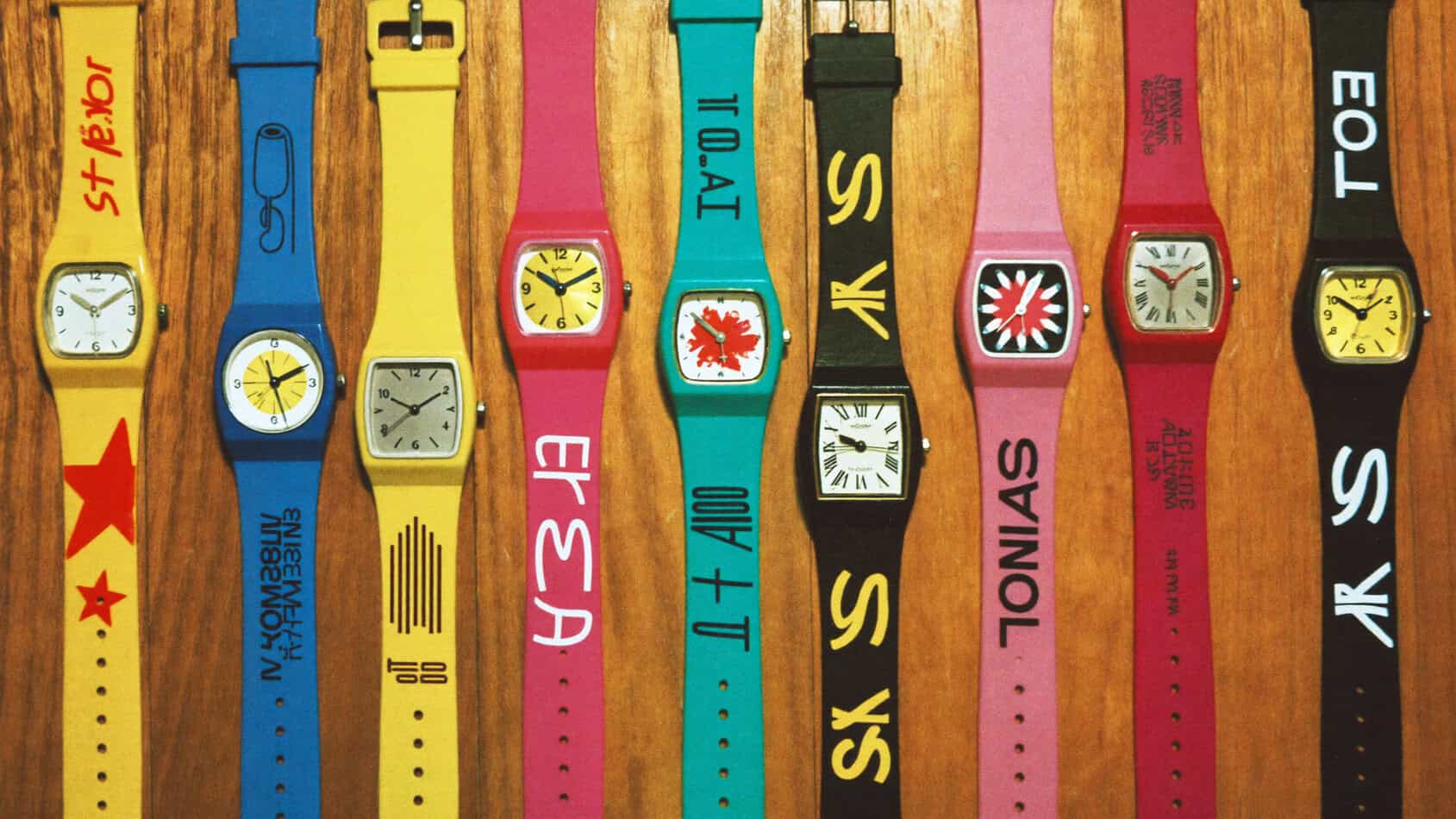 1980s Swatch watch collection flat-lay on wood surface with neon colors